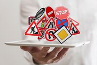 Eine Hand mit einem Tablett voller Verkehrszeichen